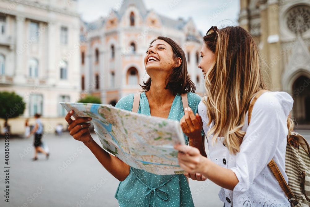 Fun, friends, travel and tourism concept. Beautiful girls looking for direction in the city because they've followed these 10 budgeting strategies.