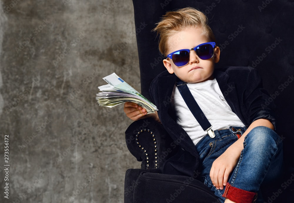 Happy boy with a bundle of money dollars cash who has a checking account cushion and Later Money.