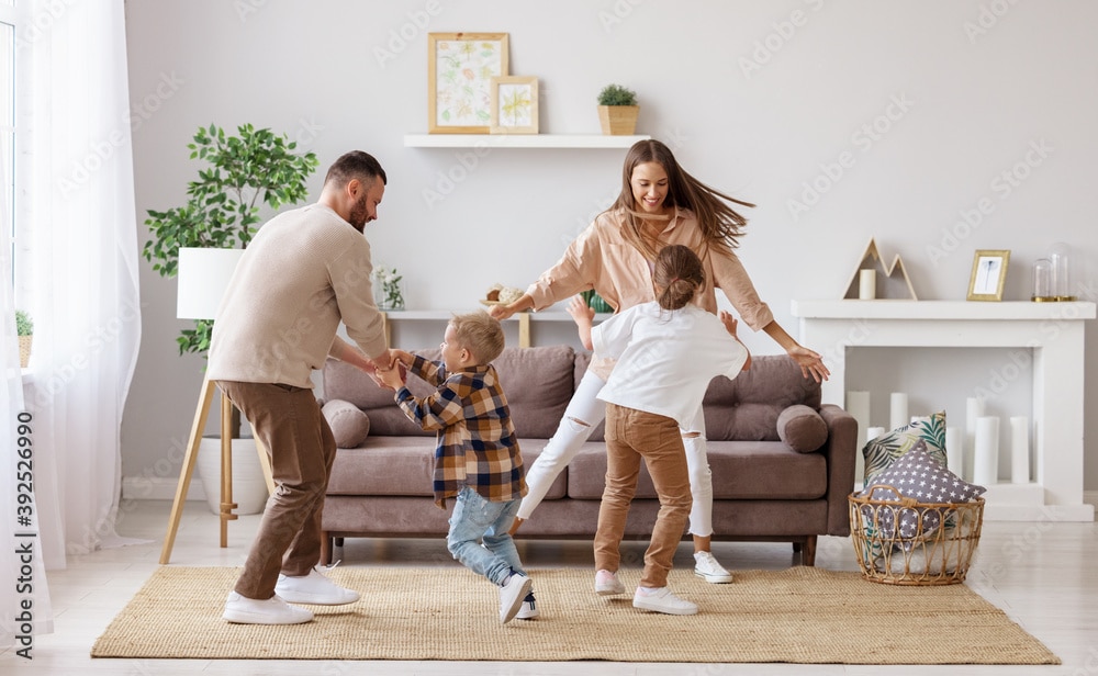 happy family mother father and children dancing at home  in their home they bought by budgeting with think and talk money.
