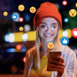 A beautiful young woman blogger, vlogger or influencer is receiving emoji and emoticon reactions in her mobile smart phone device while making a post, sharing or video logging on social media which has the consequence of us spending money we don't have and falling into debt as learned on Think and Talk Money.