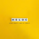 Home Equity Line of Credit (HELOC) Banner. Letter Tiles on Yellow Background. Minimal Aesthetics. A HELOC to buy an investment property can be a useful strategy in personal finance to scale your real estate portfolio if used responsibly.