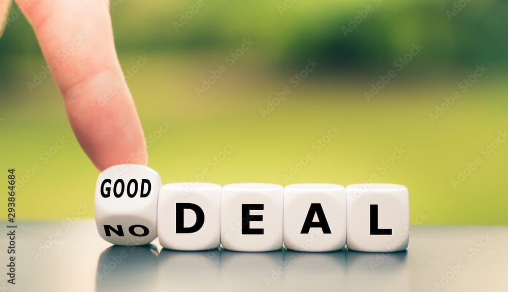 No deal or a good deal? Hand turns a dice and changes the expression "no deal" to "good deal", or vice versa illustrating the thought processs of using a credit card with a processing fee or using cash.