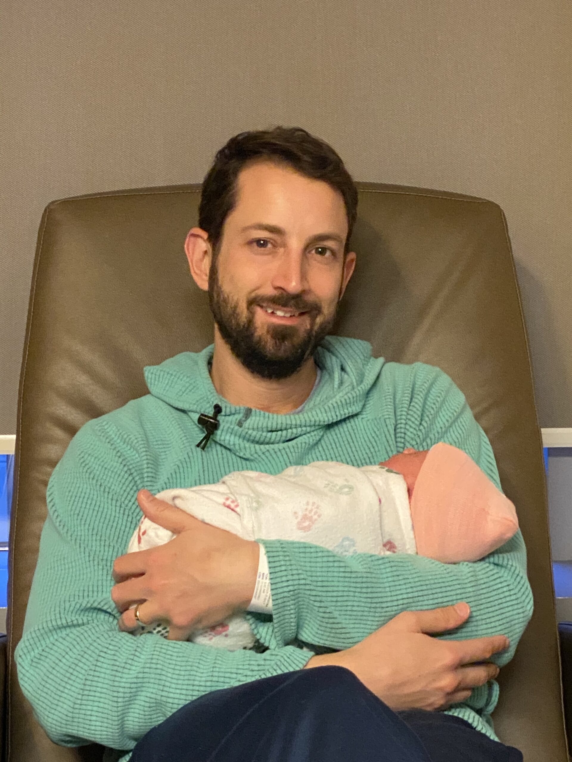Matthew Adair, founder of Think and Talk Money, holding his baby girl and reminded of his Money Why, which is to be good with money for his family.