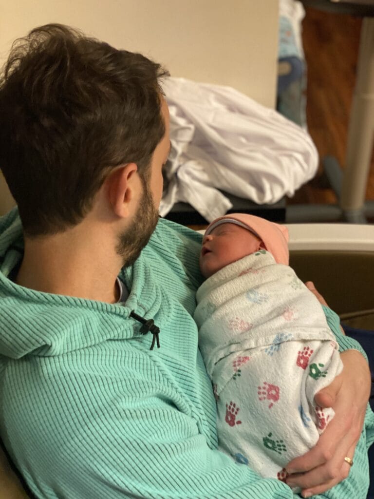 Matthew Adair, founder of Think and Talk Money, holding his baby girl and remembering why he wants to be good with money.