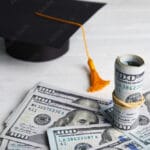 Dollar banknotes and student graduation hat on white wooden background illustrating Think and Talk Money's 10 student loan tips for lawyers and professionals.