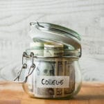 Dollar bills in glass jar isolated on wooden background. Saving money for college using a 529 plan is one of the best ways to accomplish your goals.