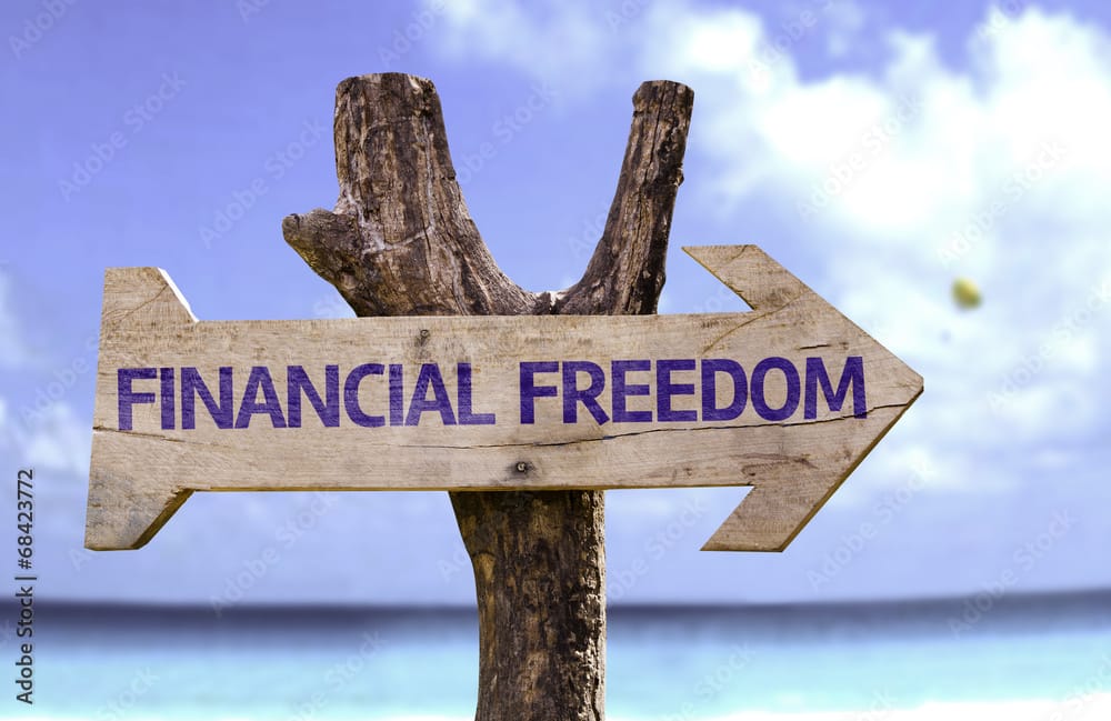 Financial Freedom wooden sign with a beach on background, illustrating that my journey to financial freedom and the journey to financial freedom for lawyers and professionals does not happen over night.