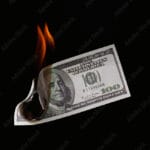 Money fire burn dollar paper illustrating how to set money on fire by taking money out of the market instead of investing.