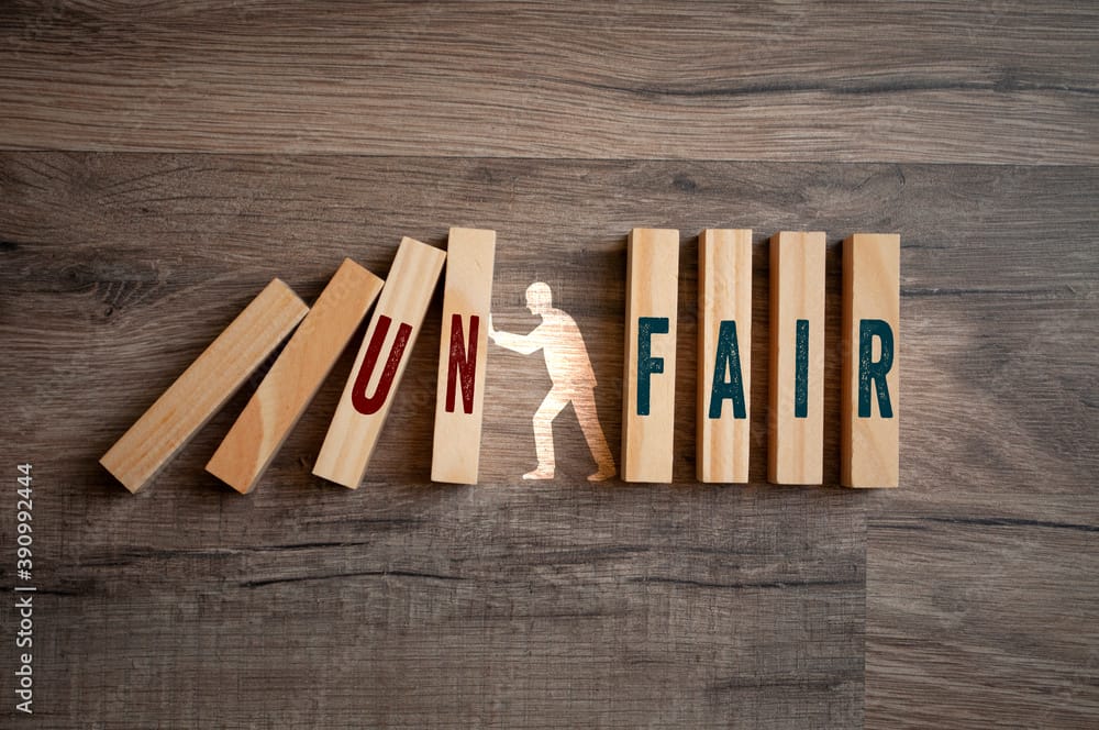 Pieces of wood with message fair and unfair on wooden background illustrating one of the 10 student loan tips for lawyers and professionals is to not miss a payment.