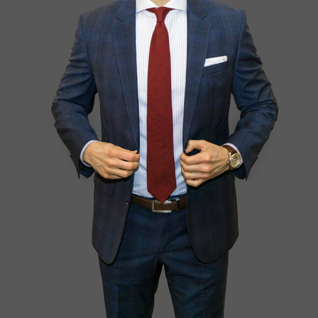 Dapper Professional wearing a blue plaid suit, a custom shirt and a silk knit red tie, illustrating a financial advisor ready to charge you "only 1%" in fees.