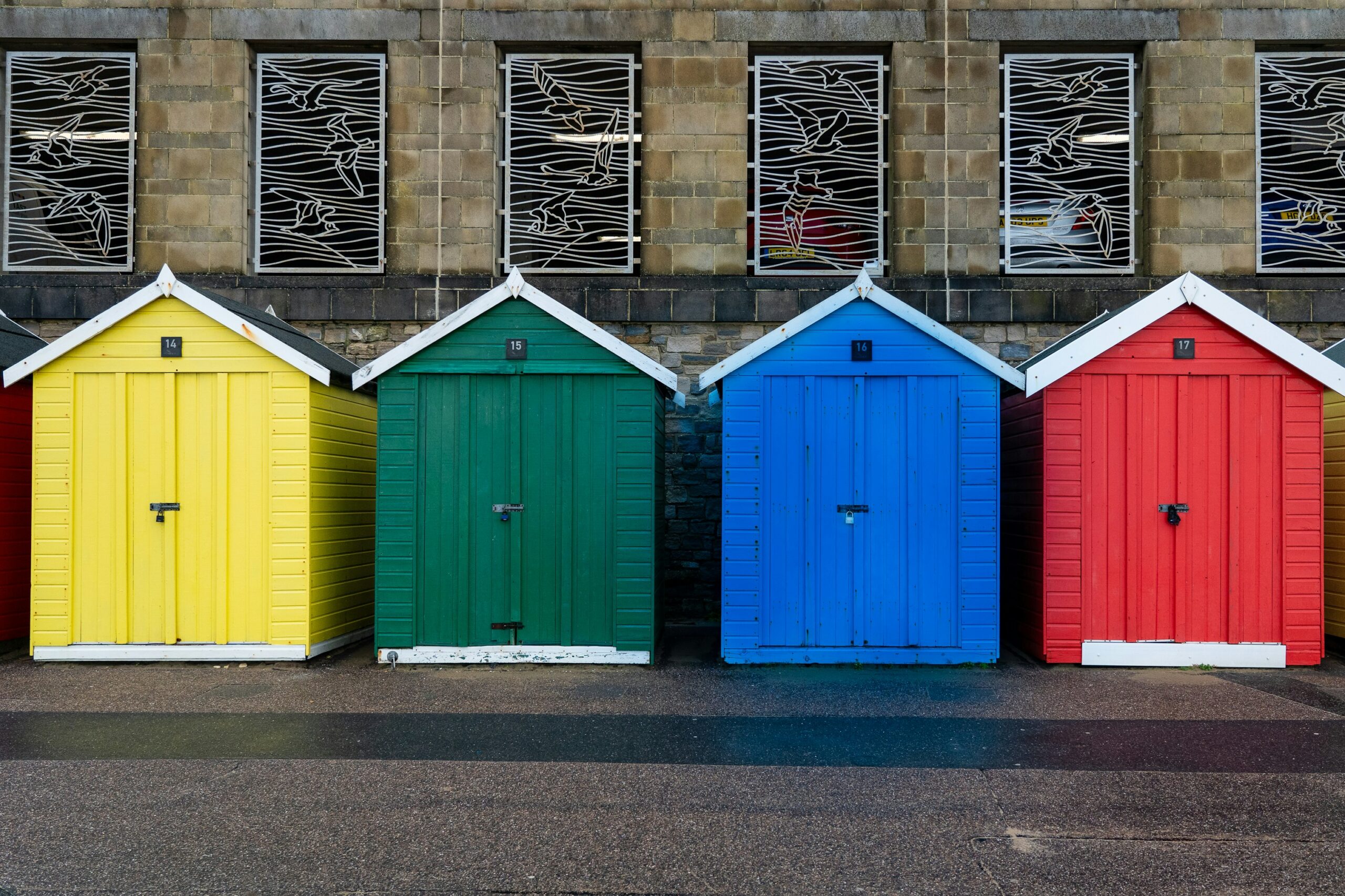 Four beach huts, each painted in the four primary colours, of yellow, green, blue and red representing my four favorite investment accounts: 401(k), Roth IRA, HSA, and 529.