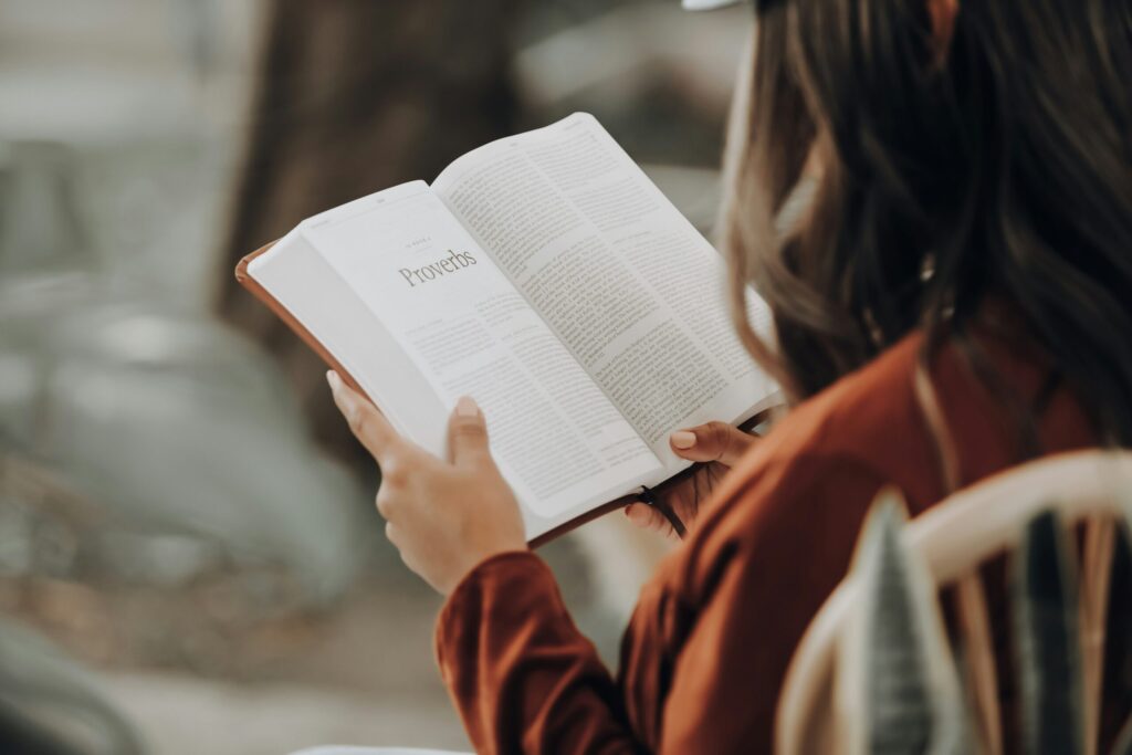 Girl reading a money mindset book to learn about the balance between life and money.