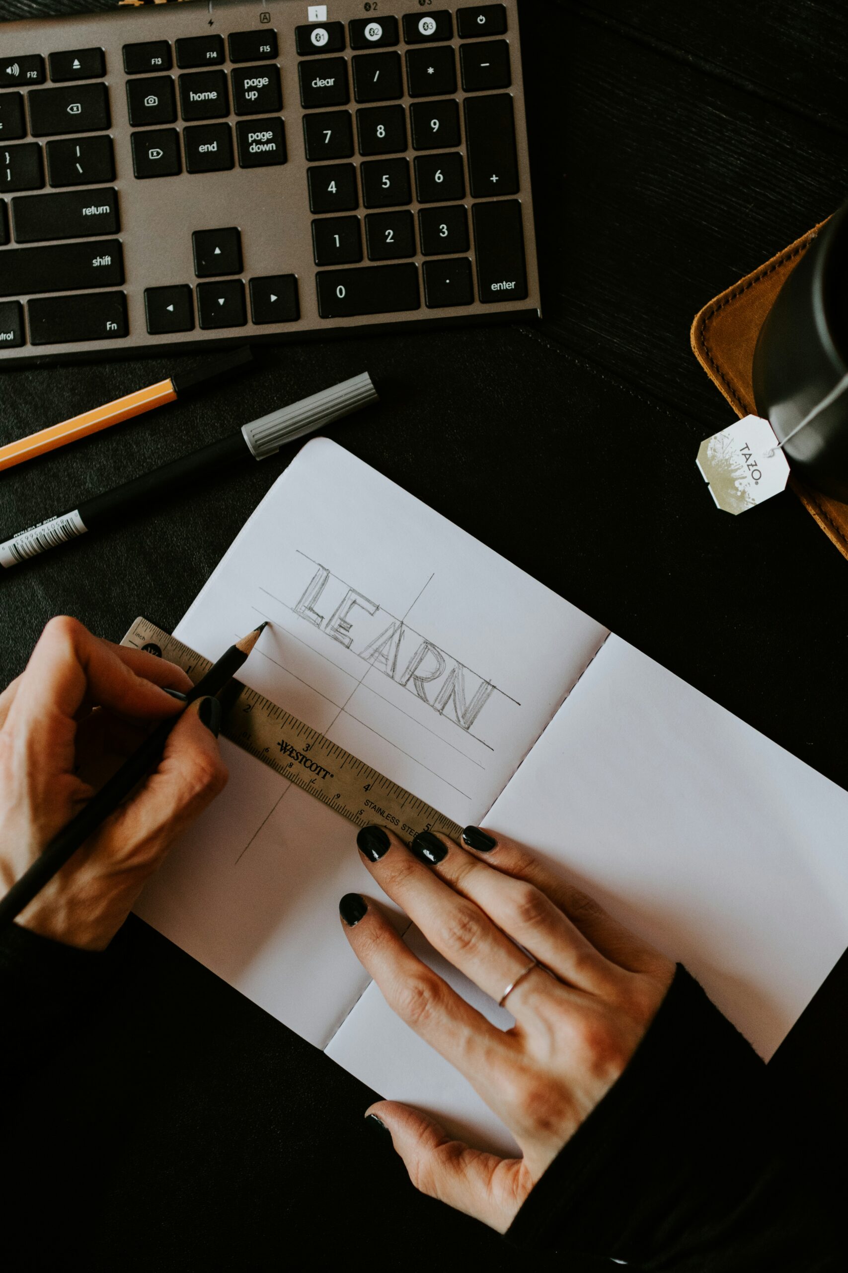 person writing learn on white paper because learning basic stock market terminology make investing in the stock market less intimidating.