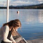 Reading a money mindset book on a Dock to help appreciate the balance between life and money.