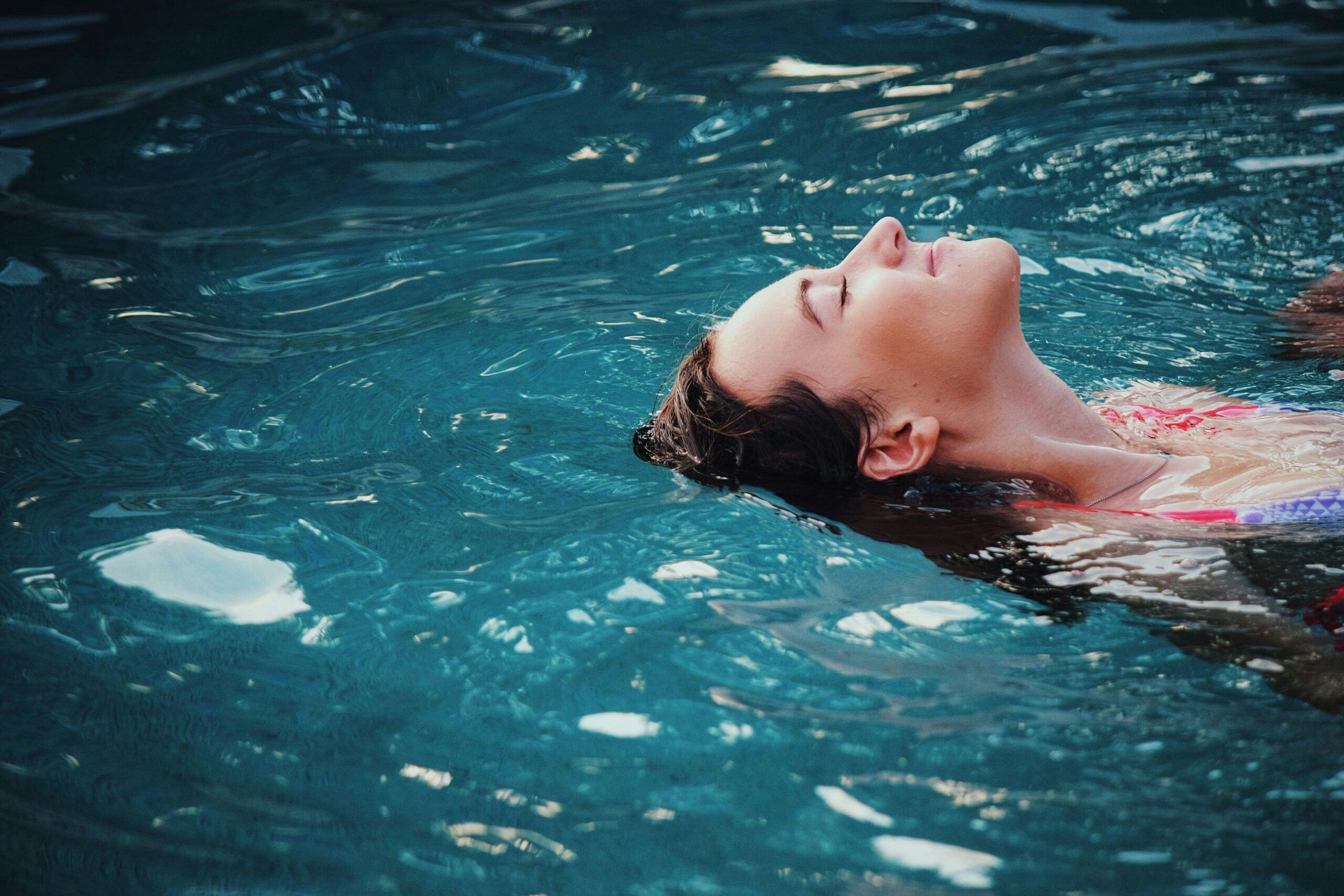 Woman relaxing on water in sunlight because she invests in index funds so doesn't worry about the markets.