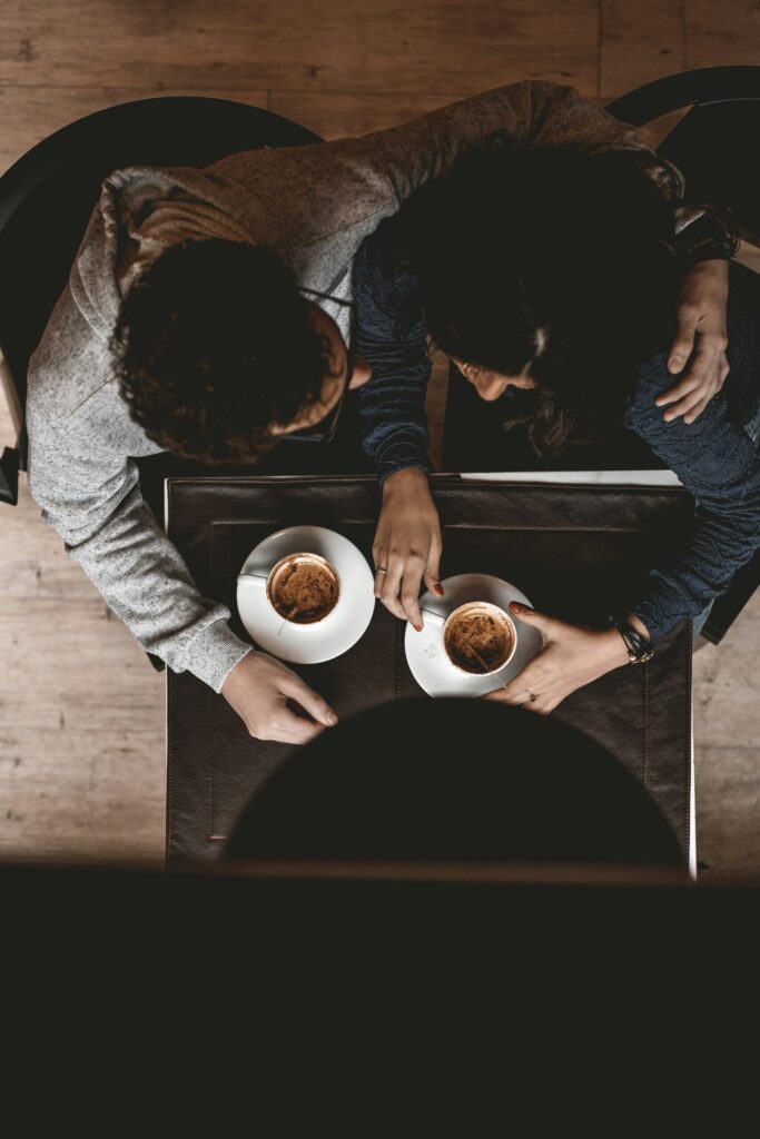 Break time with aerial view of two people hugging and talking about whether to keep two Chase Sapphire Reserve credit cards.