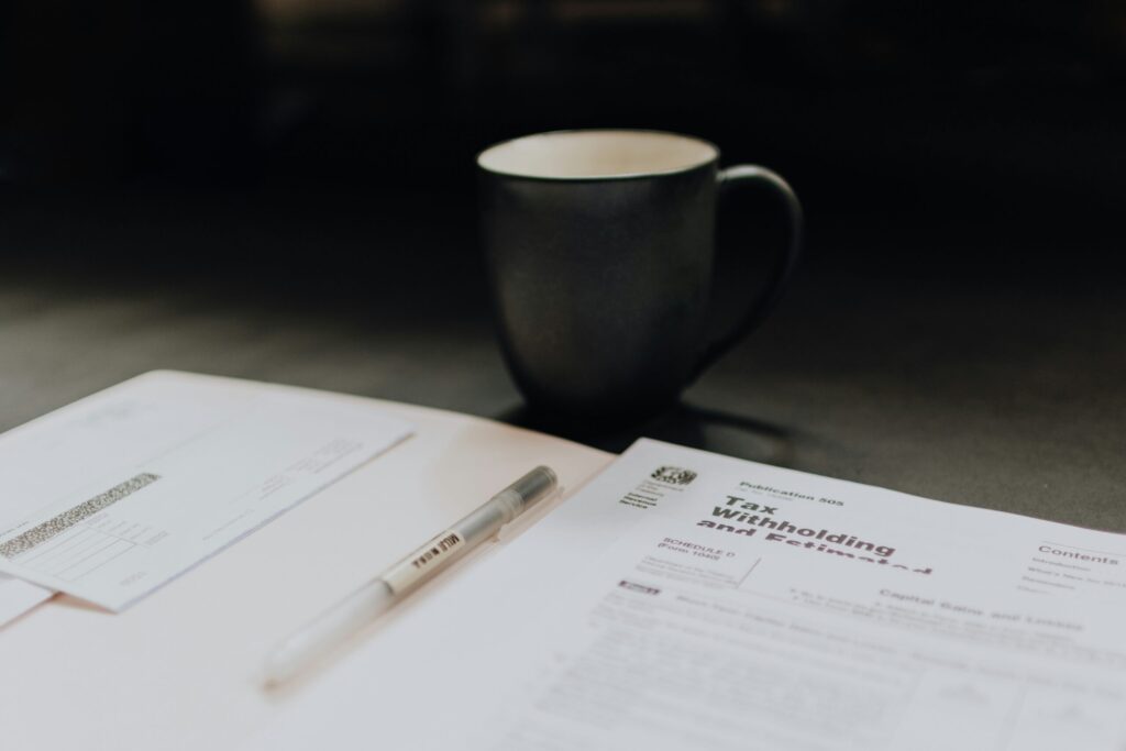 coffee mug near open folder with tax withholding paper reflecting the massive tax benefits of investing in real estate.