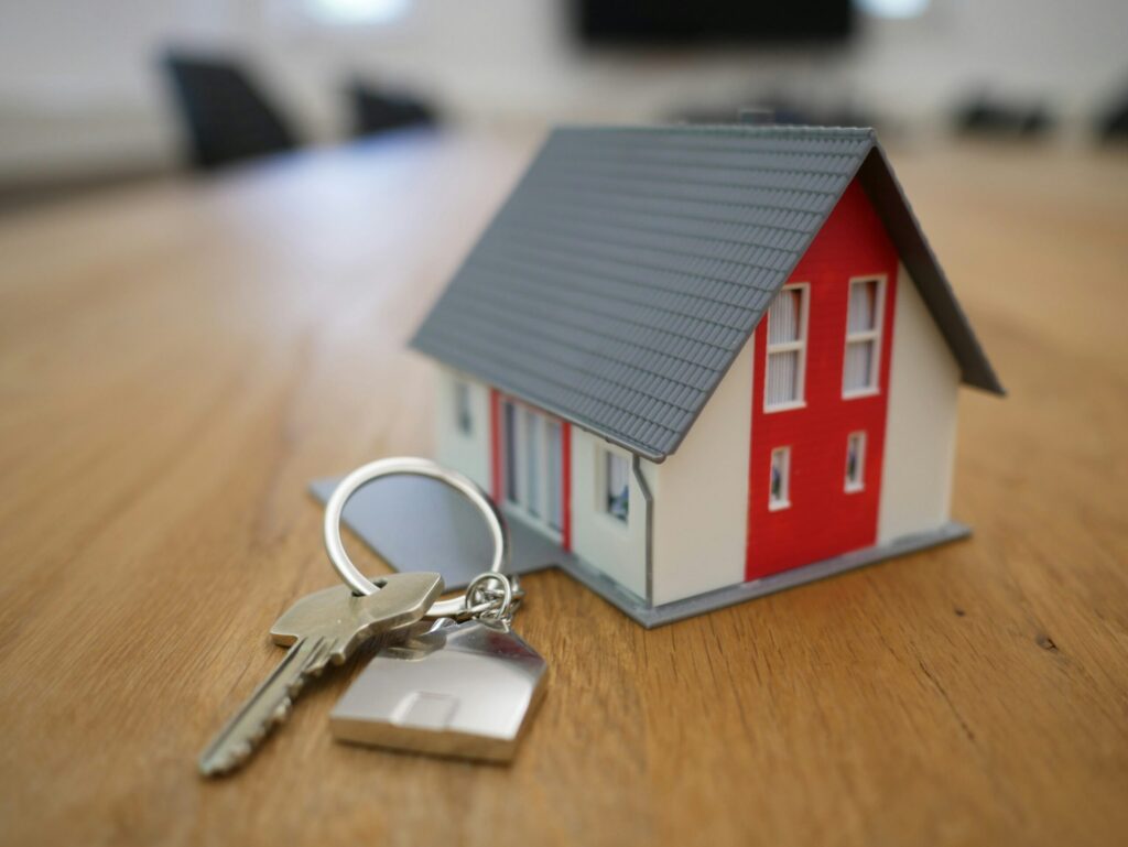 Mini house and key illustrating how to generate long-term wealth through real estate with appreciation.