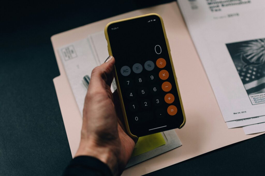 black smartphone calculator showing the number 0 indicating how to budget with two simples numbers before investing in real estate.