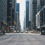 Crossing the street and city architecture and skyscrapers reflecting that I invest in rental properties in Chicago based on location, location, location.