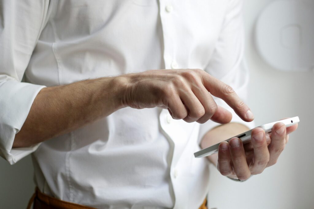 man holding a phone and texting reflecting what a good mortgage broker will do for you.