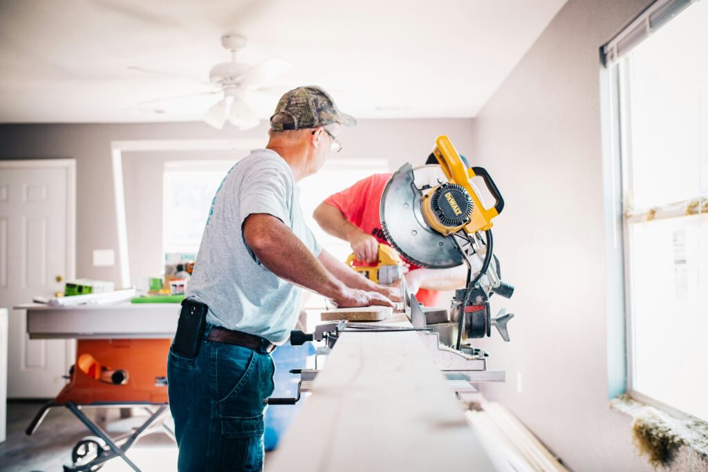 man standing in front of a miter saw reflecting the next most important people on your real estate team are your accountant, lawyer, insurance advisor, and handyman or general contractor.