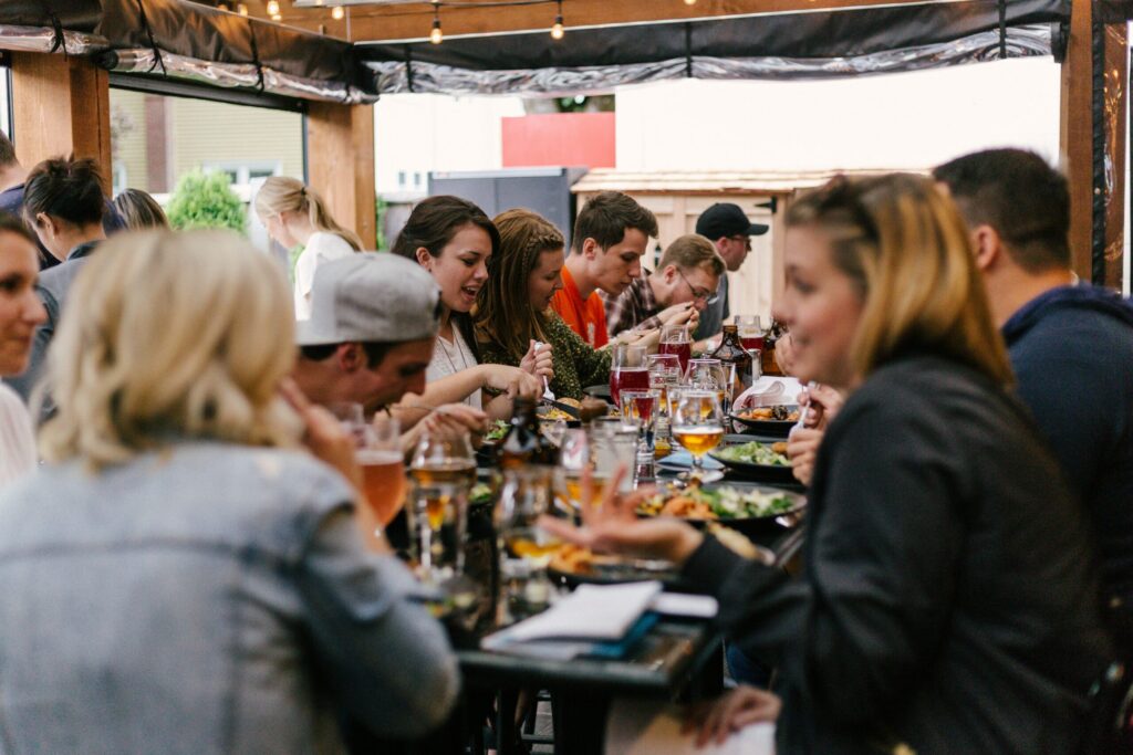 People eating a meal around a table symbolizing the importance of a good mortgage broker.