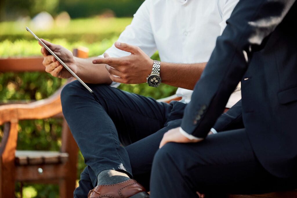 two businessmen having a meeting in the park reflecting the next most important people on your real estate team are your accountant, lawyer, insurance advisor, and handyman or general contractor.