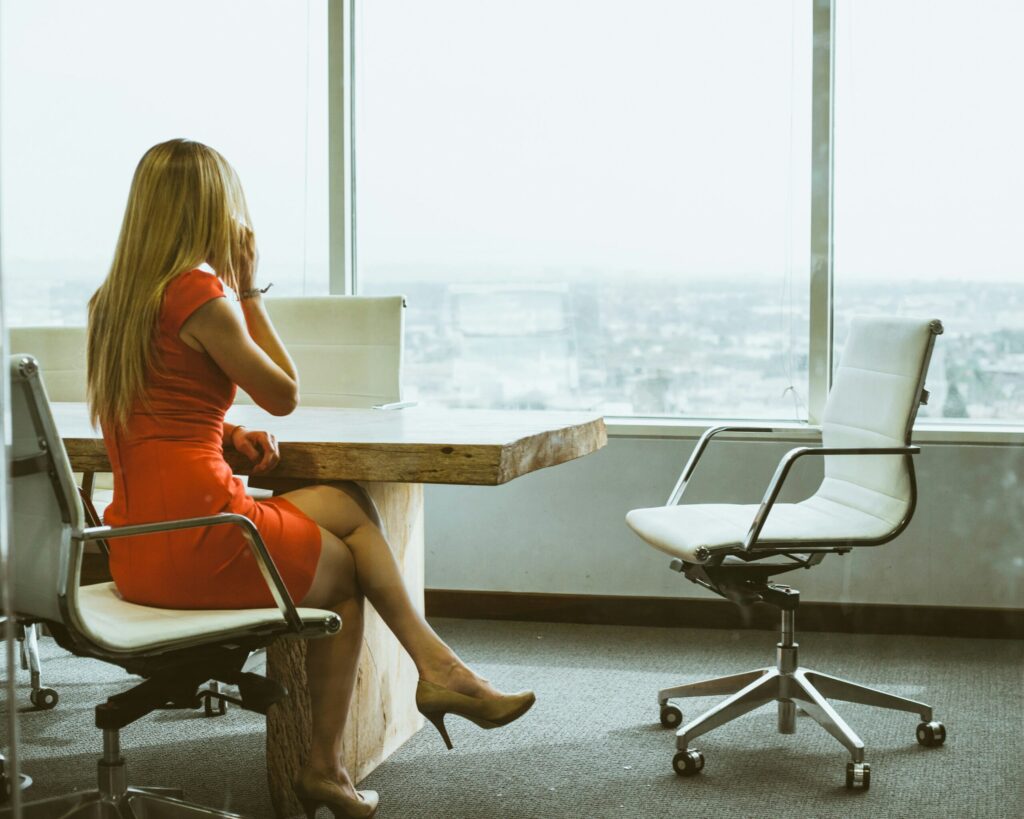 Ugmonk lady looking out window and talking on phone while closing a real estate deal.