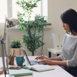 Young woman working with laptop symbolizing the importance of having a good real estate accountant on your team.