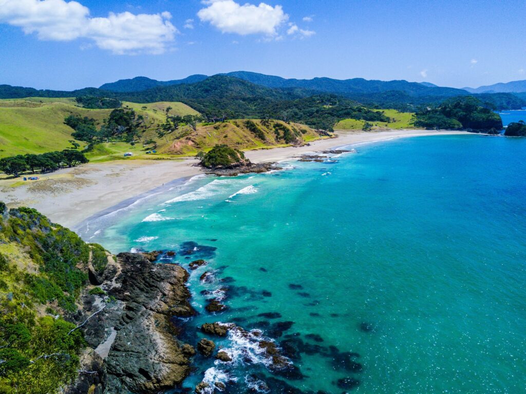 aerial view of beach with mountains in the backdrop indicating the power of coast FIRE as a money mindset hack.