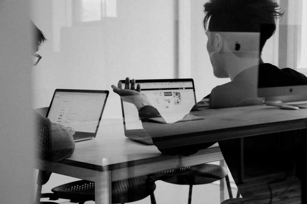 two people meeting with laptops as they run the numbers together for a potential deal.