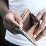 Man hand open an empty wallet showing that we all have spending choices to make when it comes to our budget.