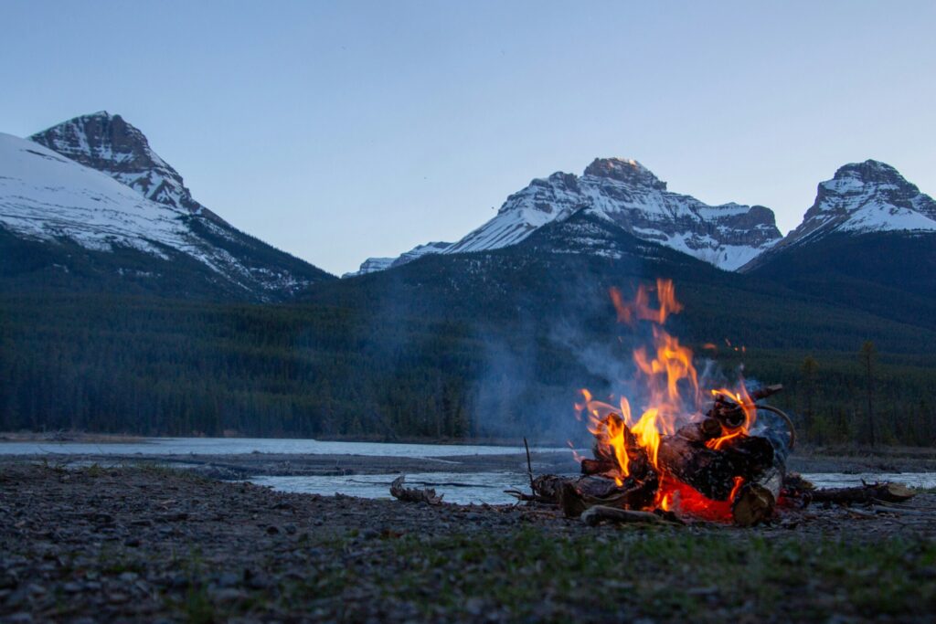 Bonfire on a coast with mountains in the background indicating the power of calculating your Coast FIRE number.