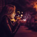 woman blowing sprinkle in her hand illustrating how one rental property can reduce your magic retirement number.