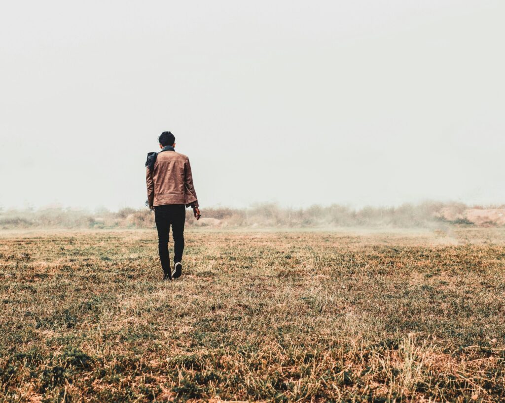 a man standing in a field with his back to the camera as evidence that sometimes it's better to split up with tenants that aren't working out.