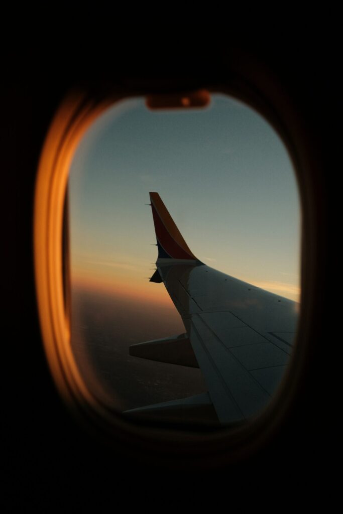 a view of the wing of an airplane through a window indicating that you should select one airline that matches your credit card travel partners.