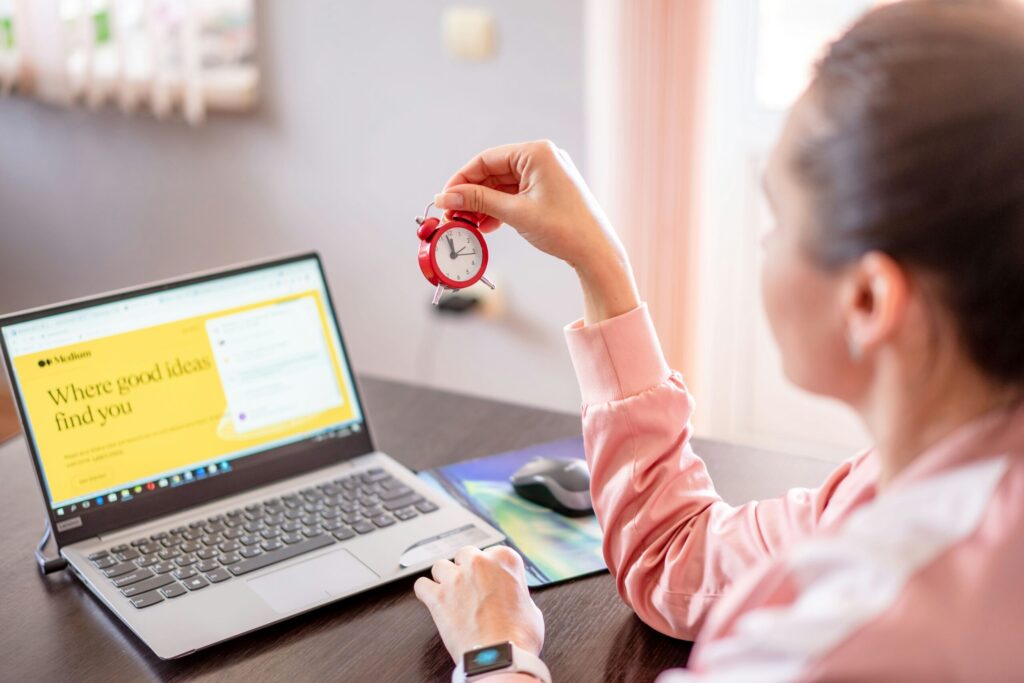 a woman sitting a desk with a a laptop computer representing what we can control in life like our saving rate.