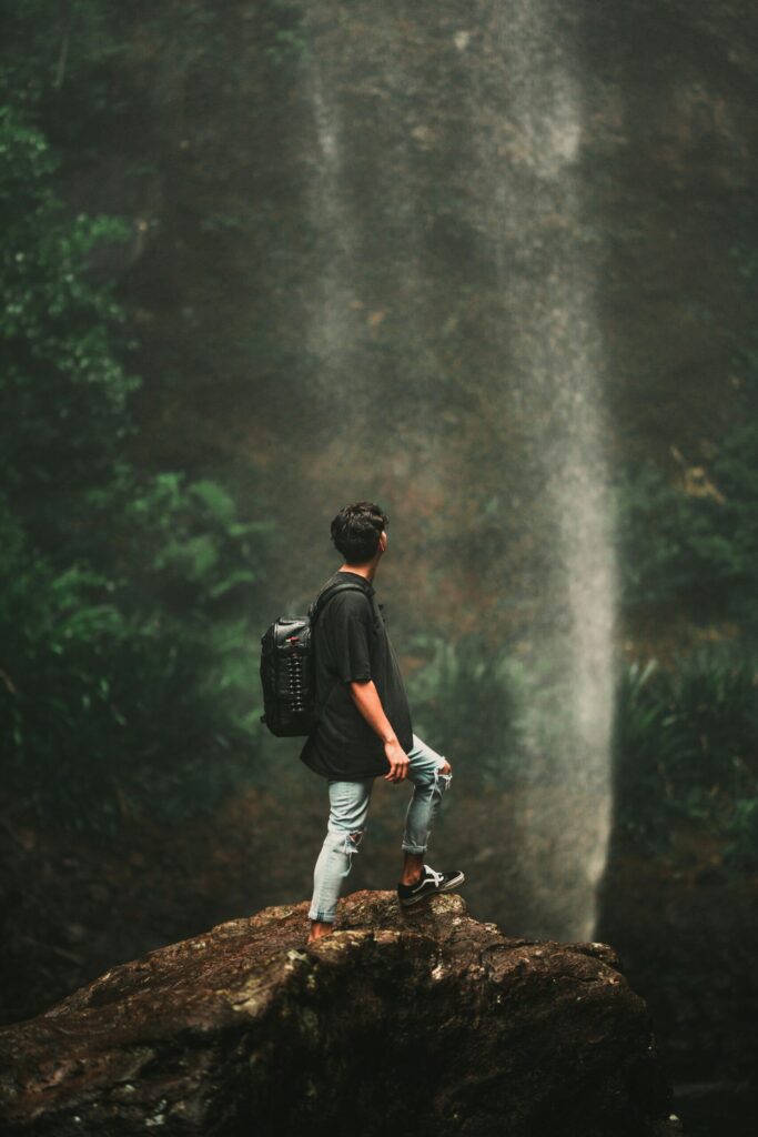 man in front of waterfall representing what you can do to accomplish your 2025 money goals.