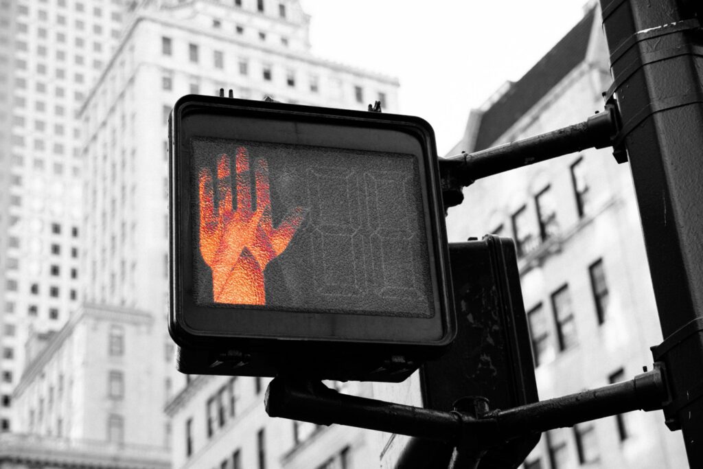 closeup photo of street go and stop signage displaying wait reflecting whether now is the right time to refinance with rates dropping.