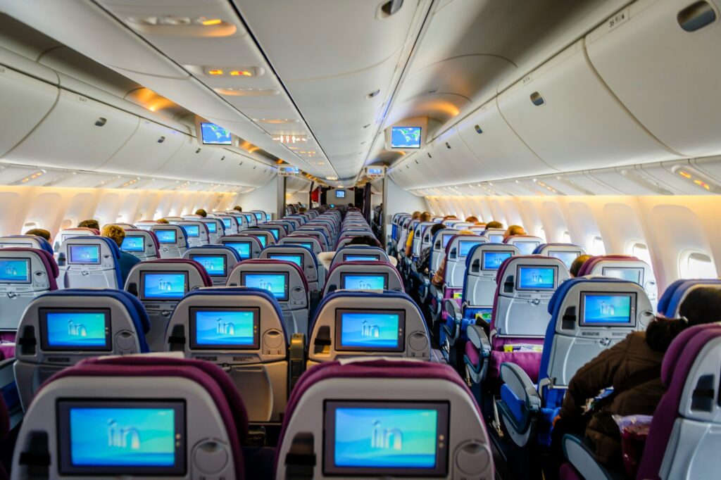 empty airplane with video screens on the back of the seat showing how to pay for free flights with your Chase sapphire reserve and freedom unlimited credit cards.