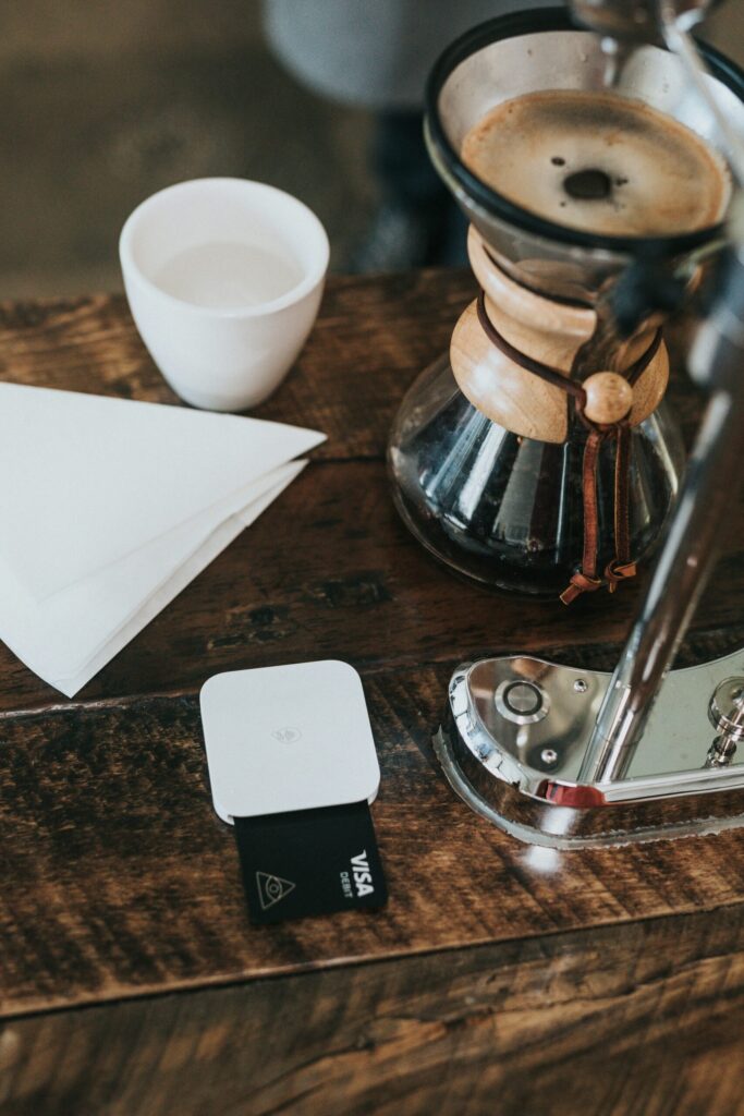 white ceramic cup with credit card and coffee pot indicating how I earn free flights using my sapphire reserve.