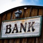 bank sign on the side of wooden building reflecting the credit card tip of not letting the bans get richer off of you.