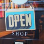 Open shop sign indicating that we should spend money based on our wealth not only on our income.