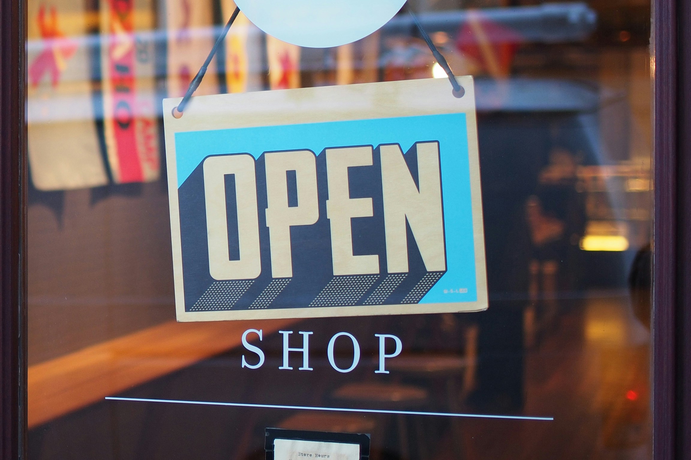 Open shop sign indicating that we should spend money based on our wealth not only on our income.