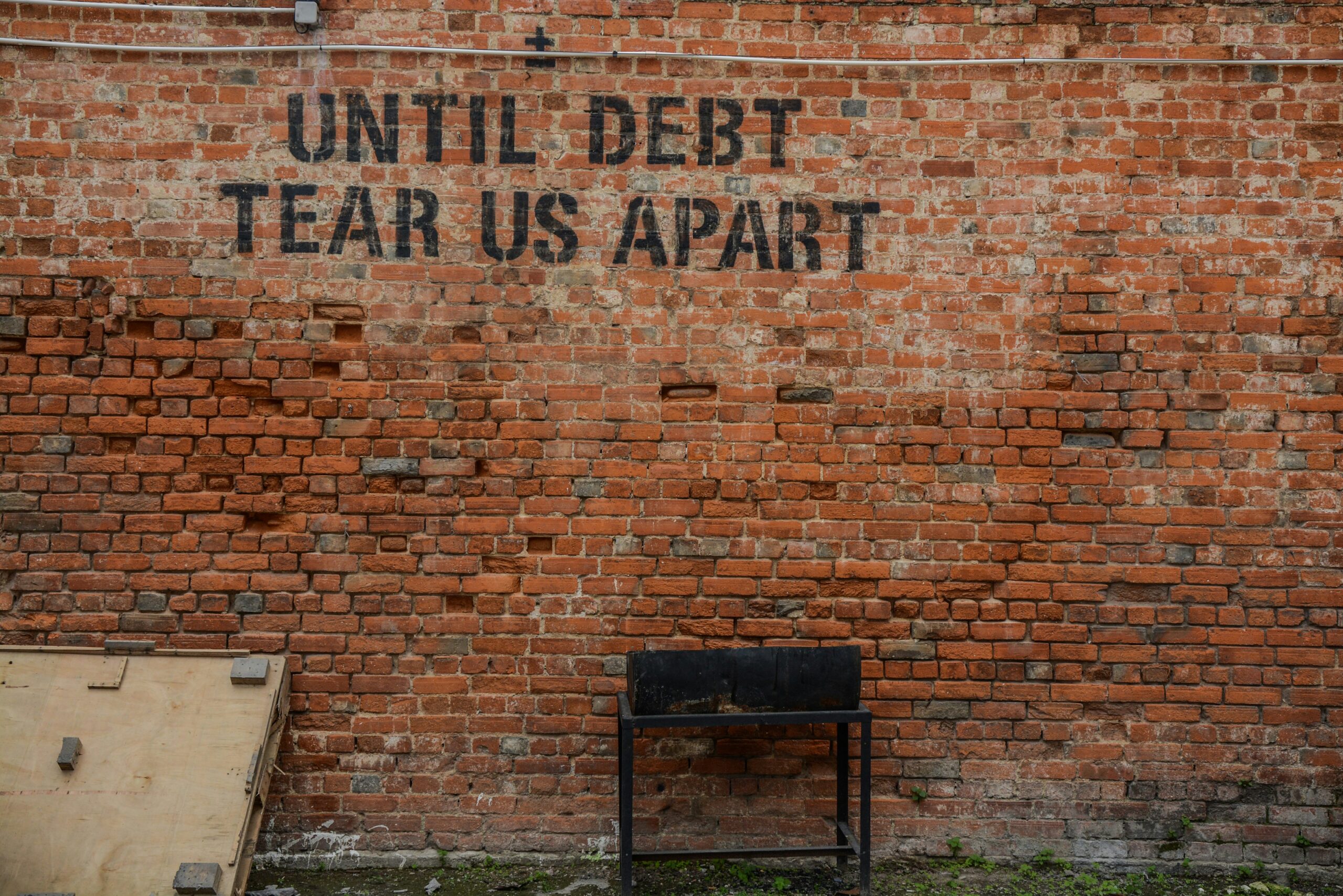 Until debt tear us apart written on a wall indicating how to make a budget to pay off debt.
