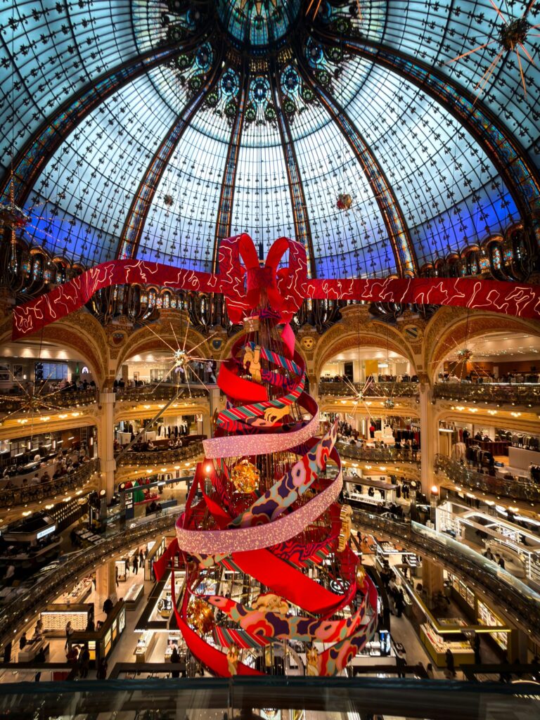 Galleries lafayette with big Christmas tree illustrating the challenges of staying on budget during the holiday season and why you need my four tips to stay on budget for the holiday season.