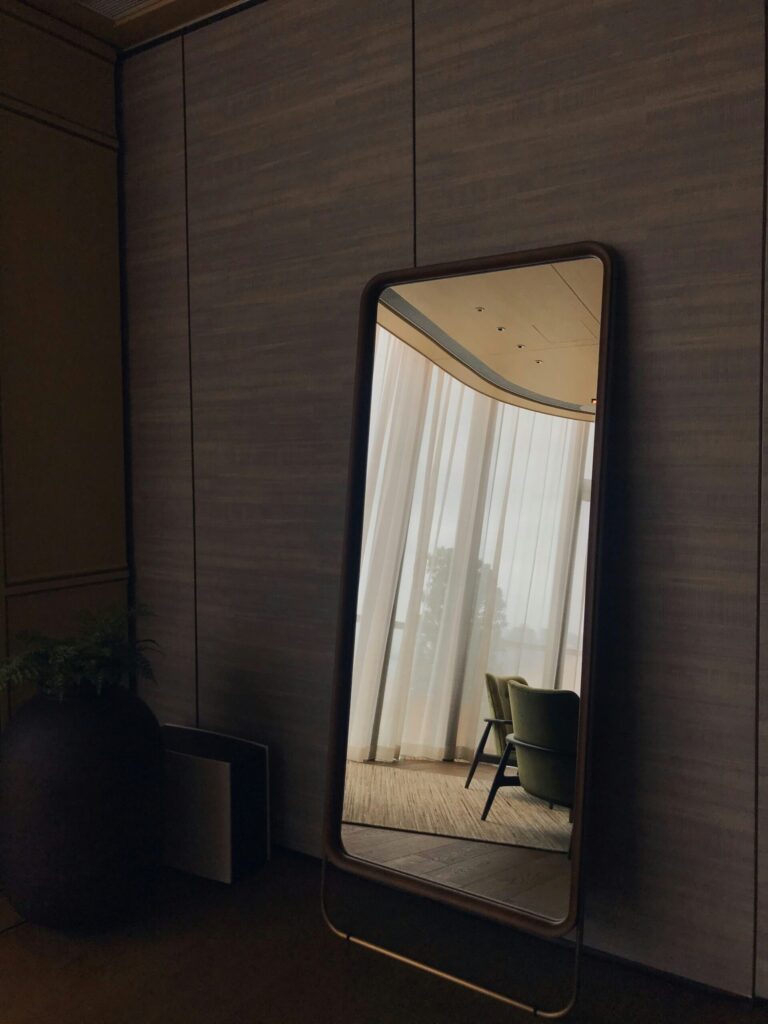 mirror in a quiet room symbolizing that we need to invest in ourselves at think and talk money.