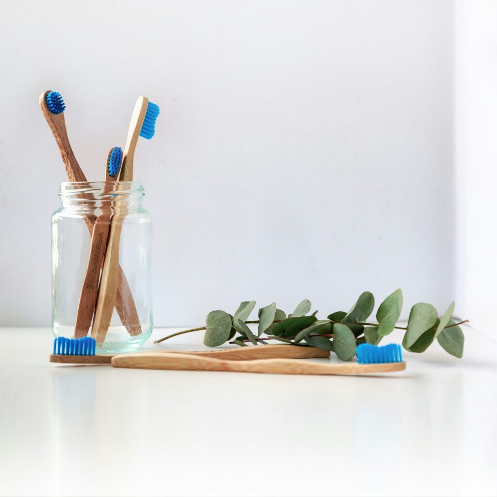 blue and white toothbrush in clear glass jar representing that lawyers and dentists have similar financial challenges at the beginning of our careers.